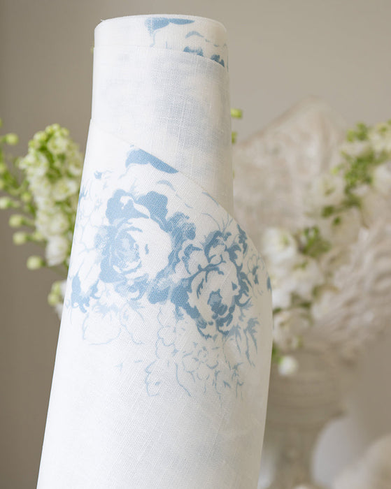 Roll of oilcloth with blue floral design against a neutral background