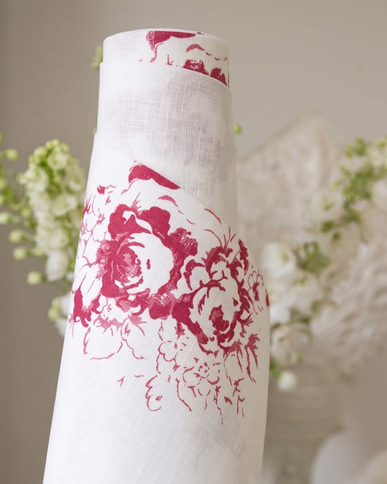 White vase with red floral patterns against a blurred floral background