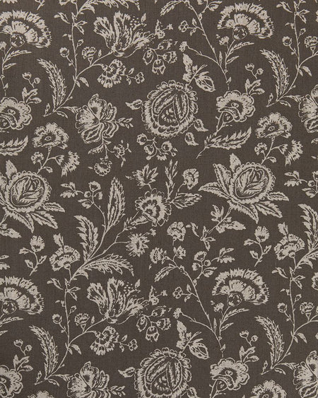 A close-up image of a fabric with a floral toile pattern in a charcoal gray color on a natural linen background.